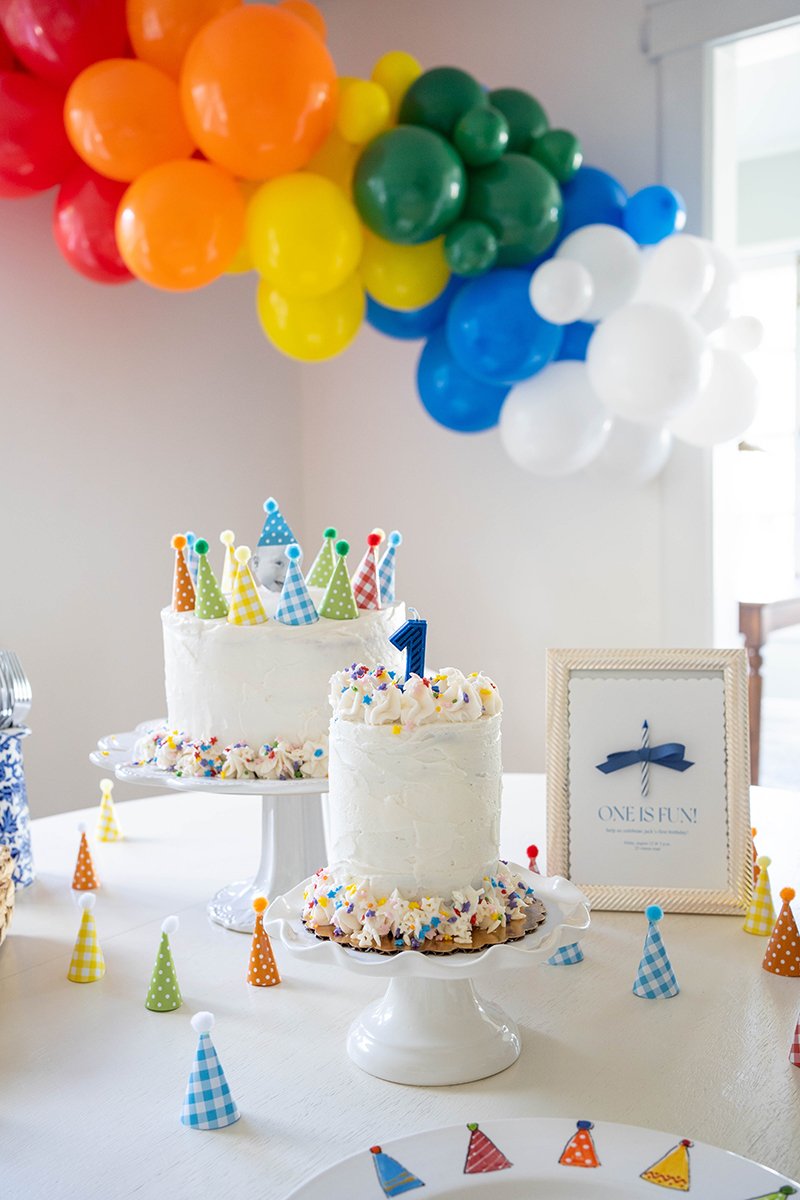 first birthday idea with smash cake, balloon garland, and party hats