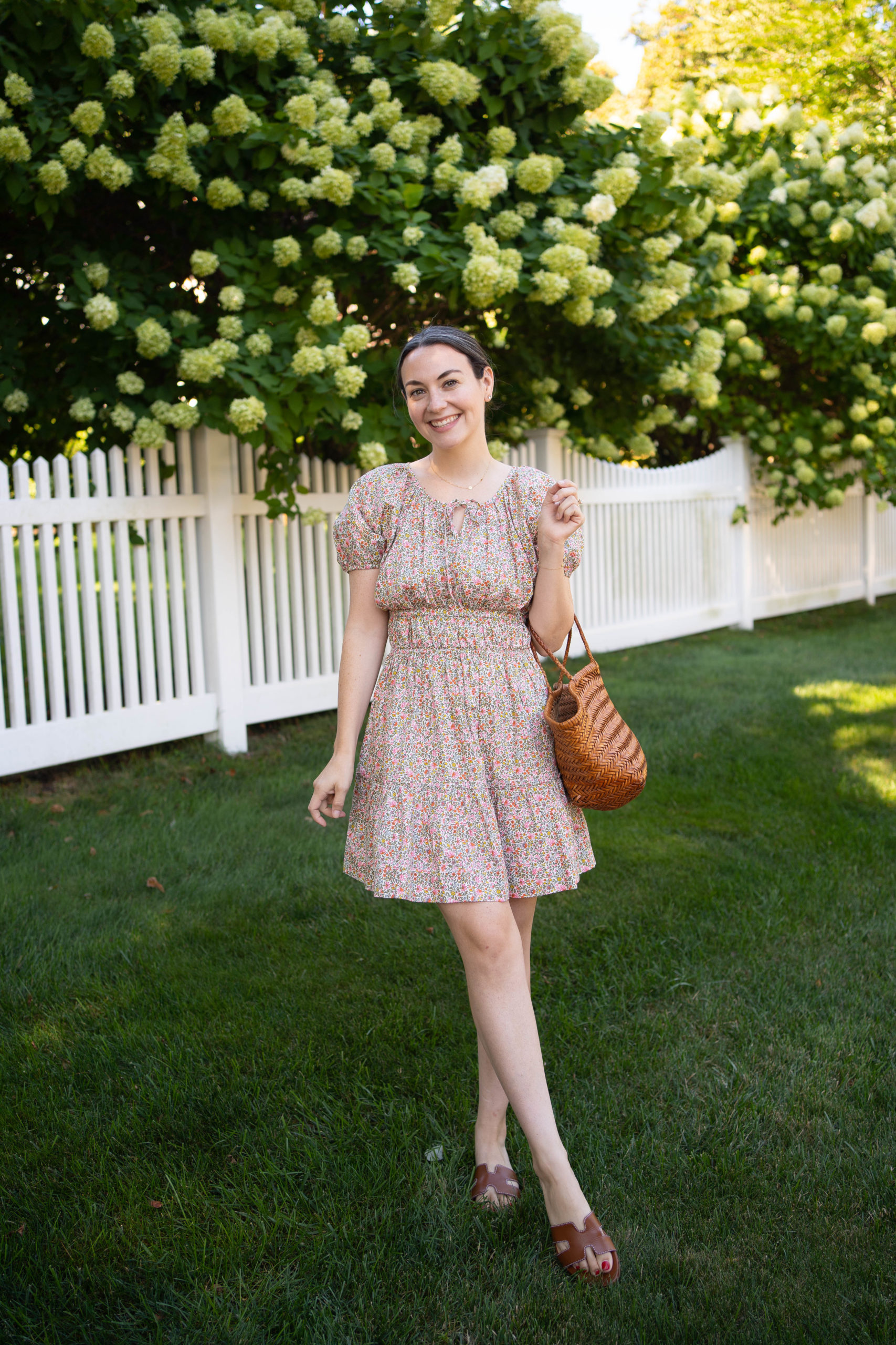 Carly Riordan wearing the J. Crew cinched-waist puff-sleeve dress in scattered blooms floral print.