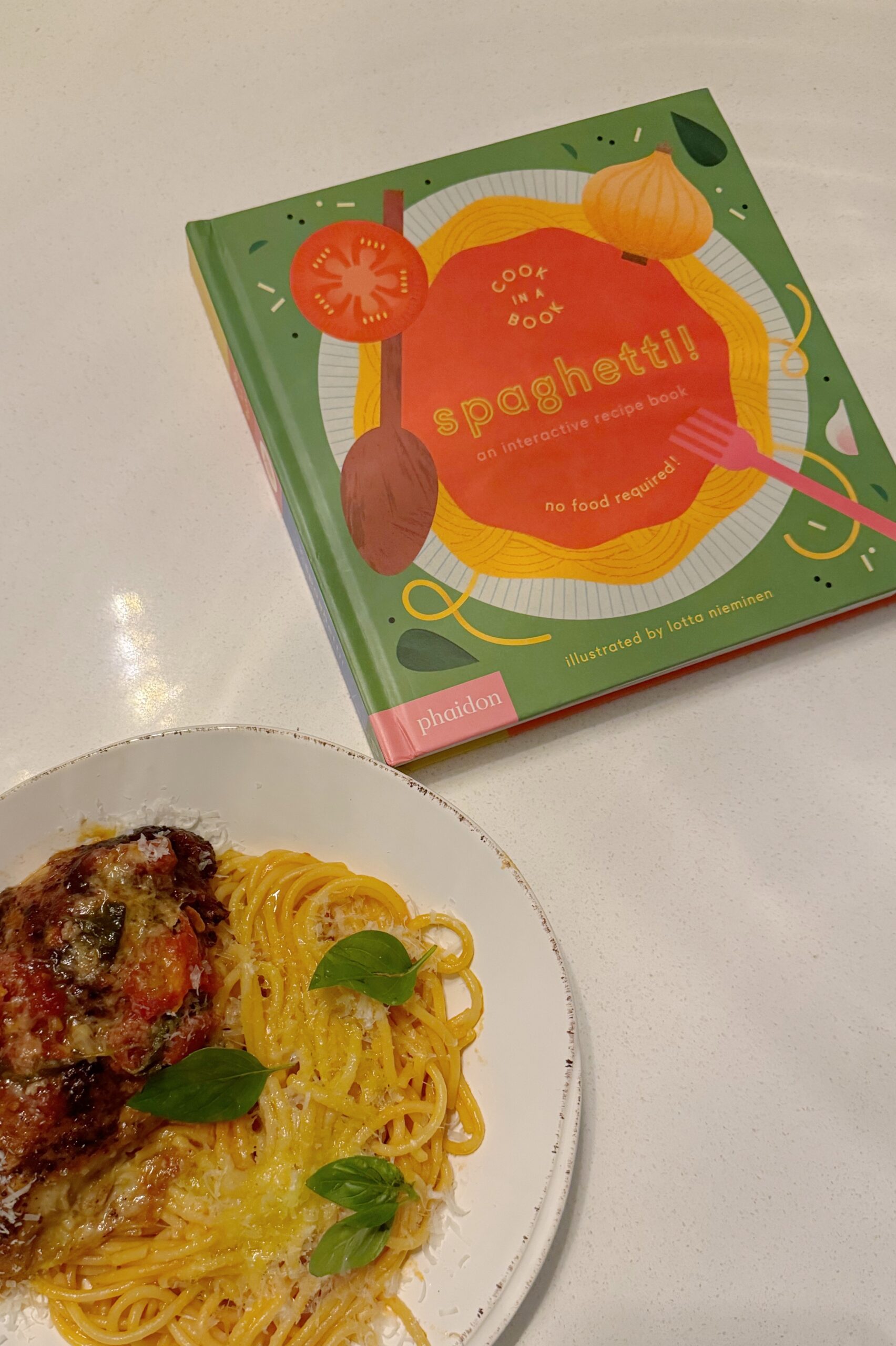 A plate of spaghetti with a children's book about spaghetti