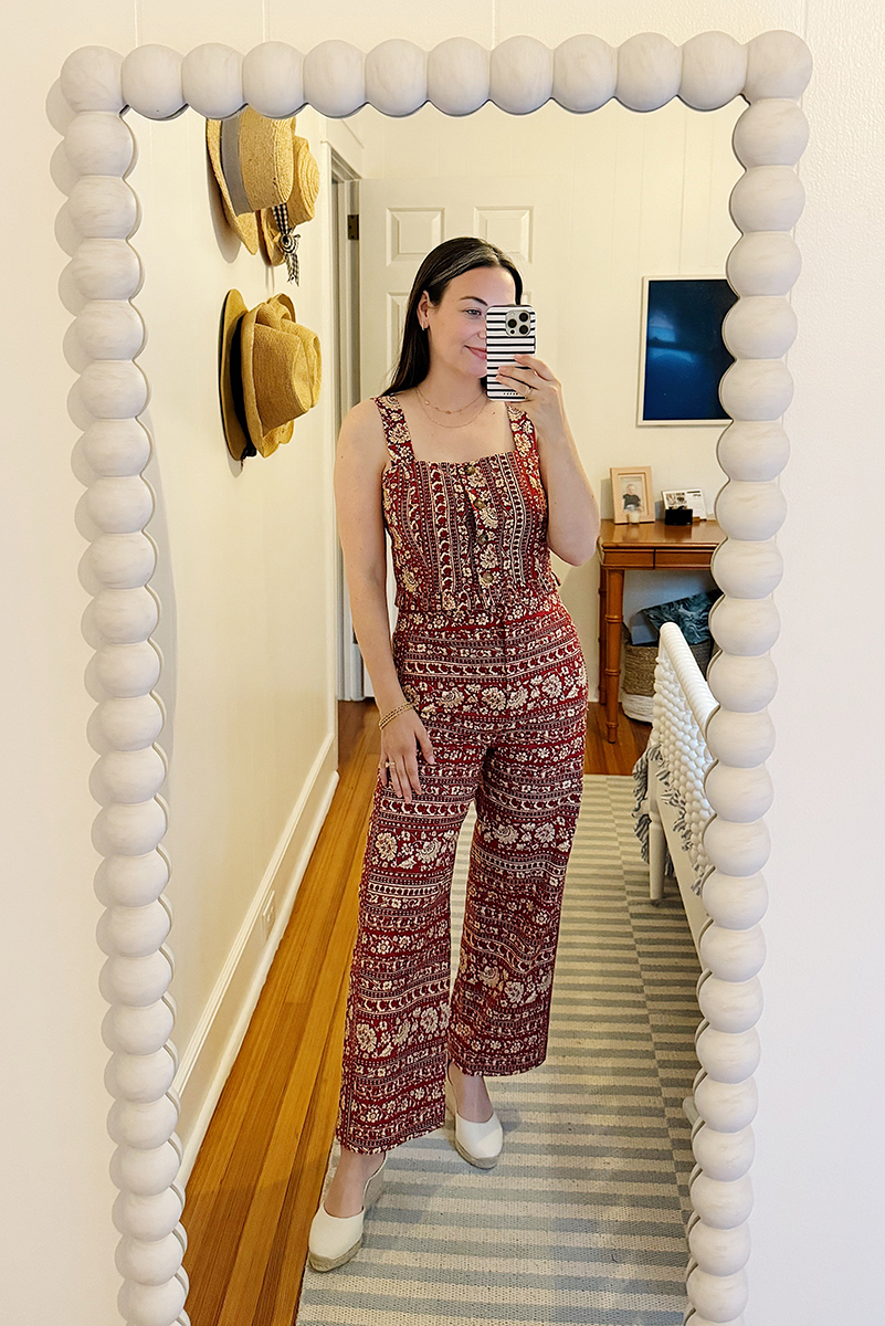 Carly taking a mirror selfie wearing a red and cream matching set.