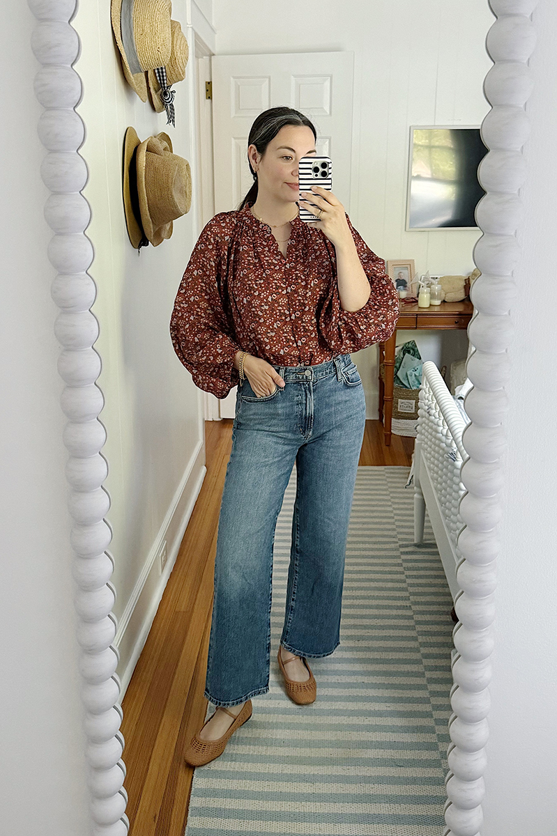 Carly Riordan taking a mirror selfie wearing a floral top. 