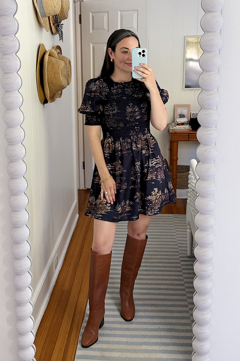 Carly Riordan in a mirror selfie wearing a Hill House nap dress and knee high boots.