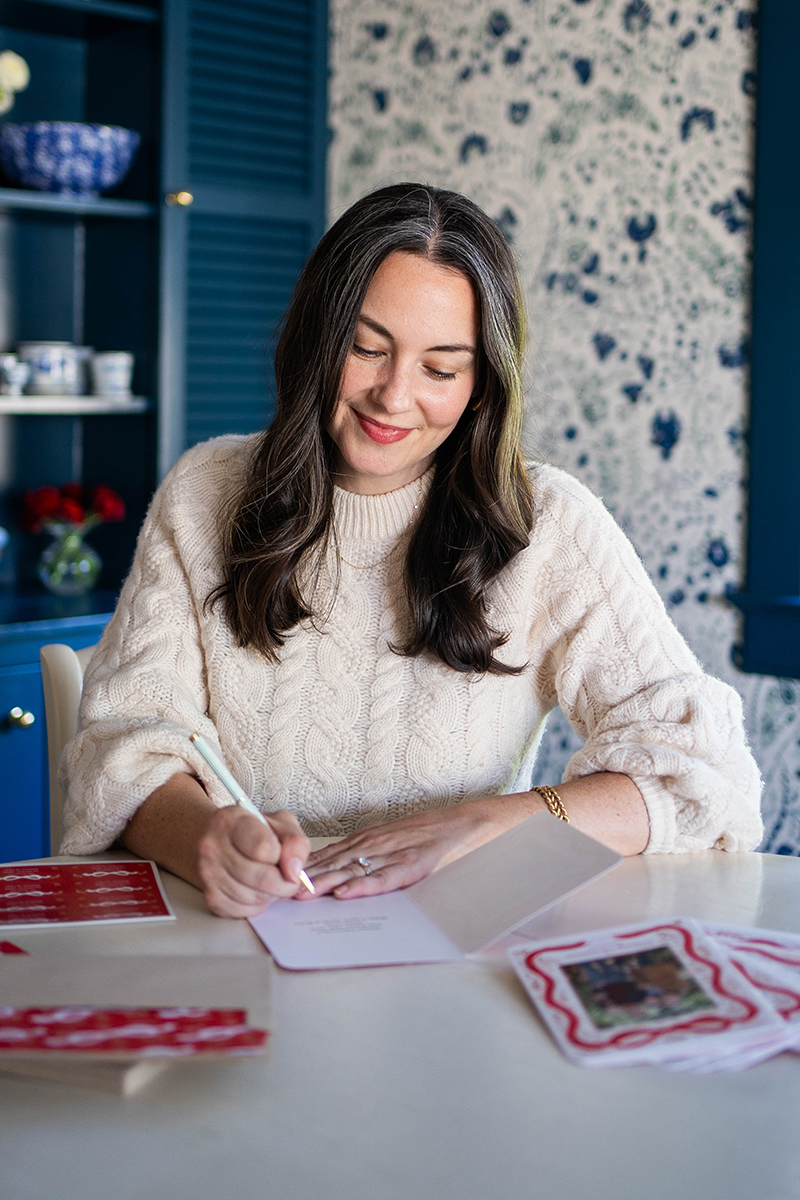 Carly Riordan writing a personalized note in her holiday cards from Shutterfly