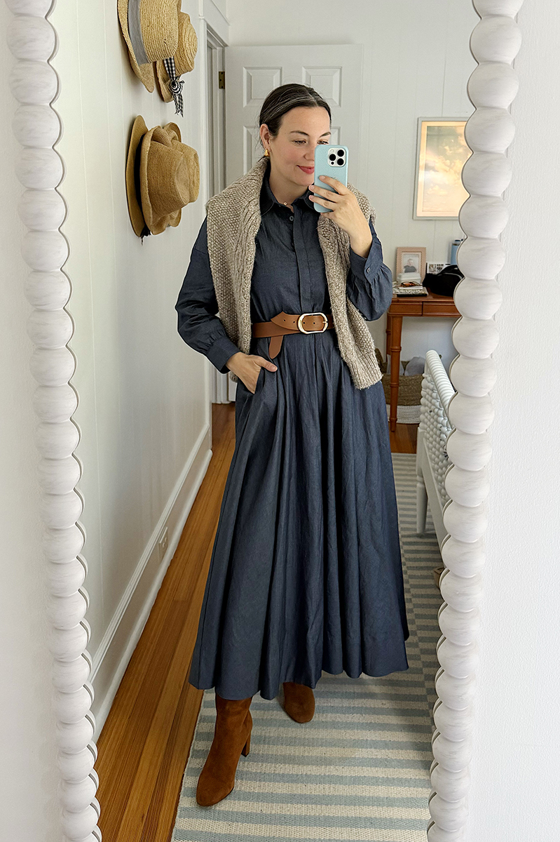 Carly Riordan wearing a long denim dress, belt, and suede boots.