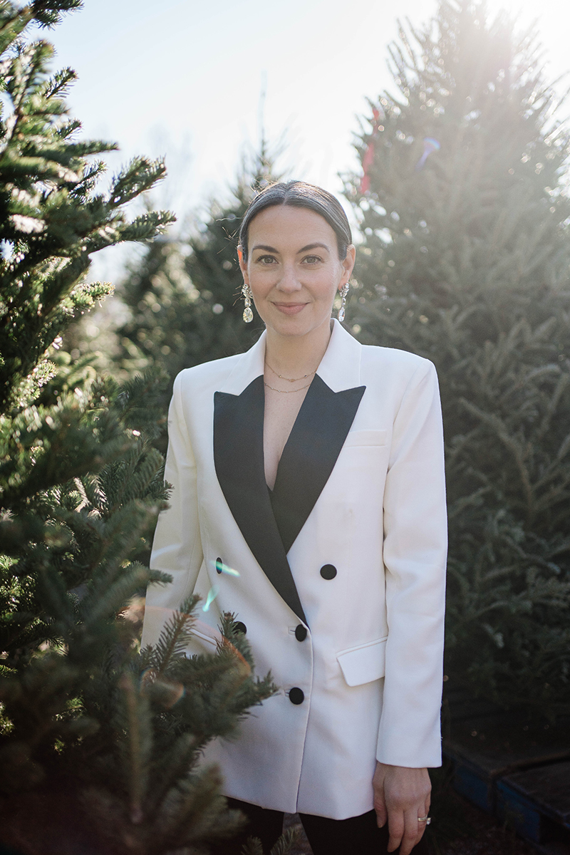 Carly Riordan in a white and black tuxedo.