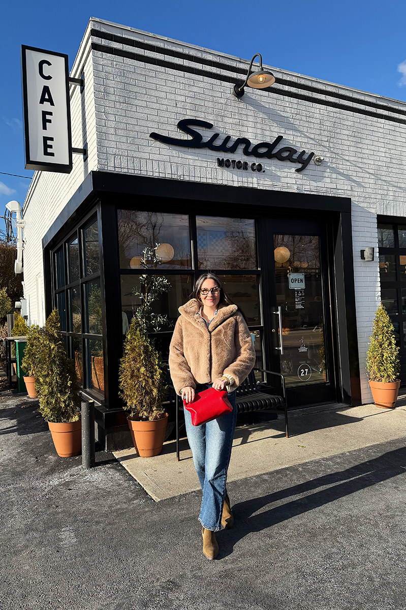 Carly walking outside of a cafe