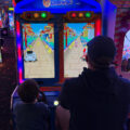 Father and son playing a game at an arcade