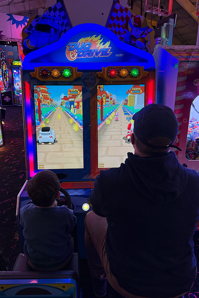 Father and son playing a game at an arcade