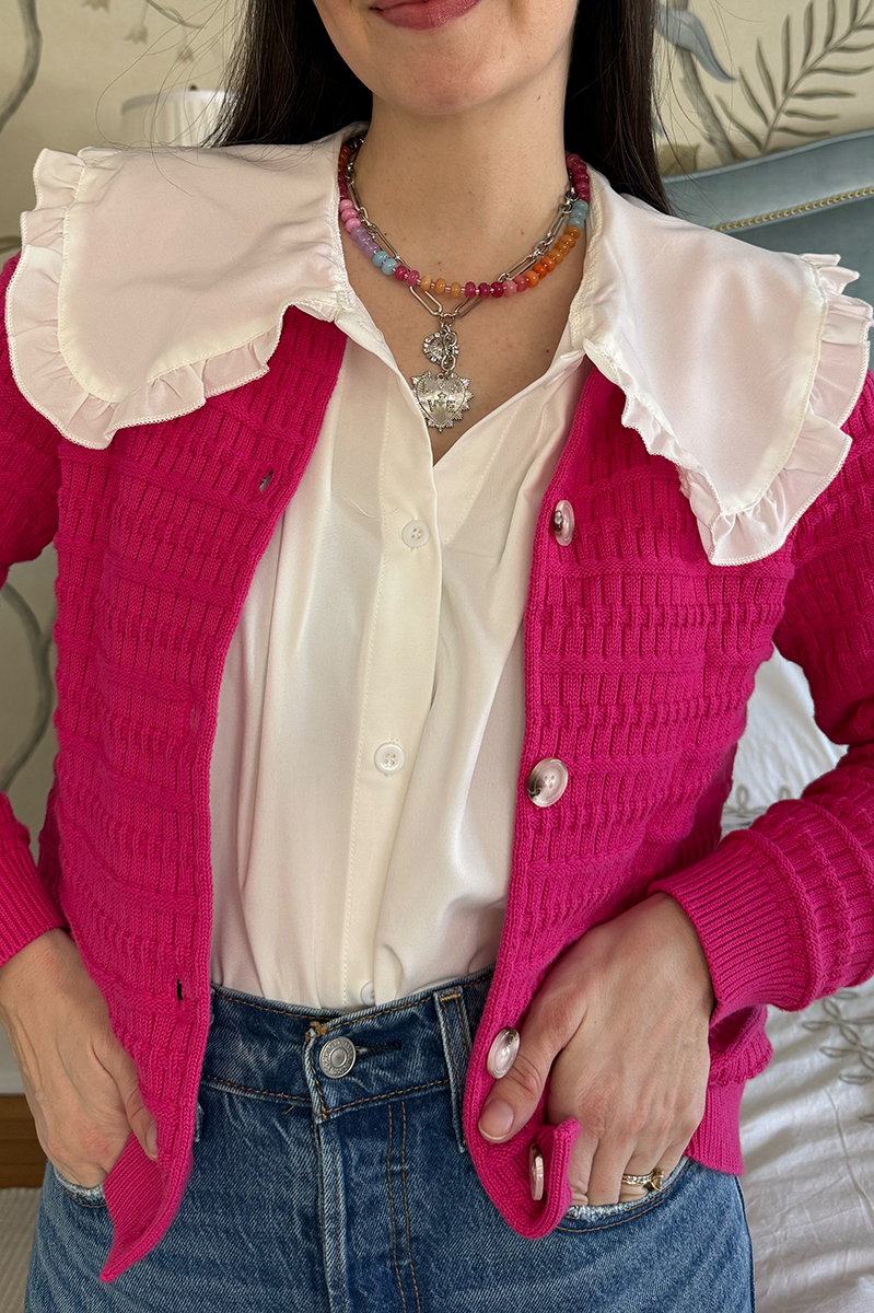 Carly wearing a hot pink sweater and colorful beaded necklace