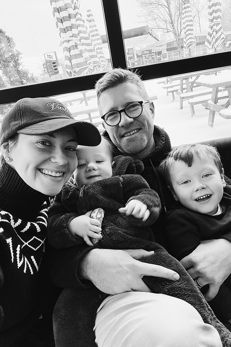 A black and white photo of Carly and her family inside of a cozy cafe