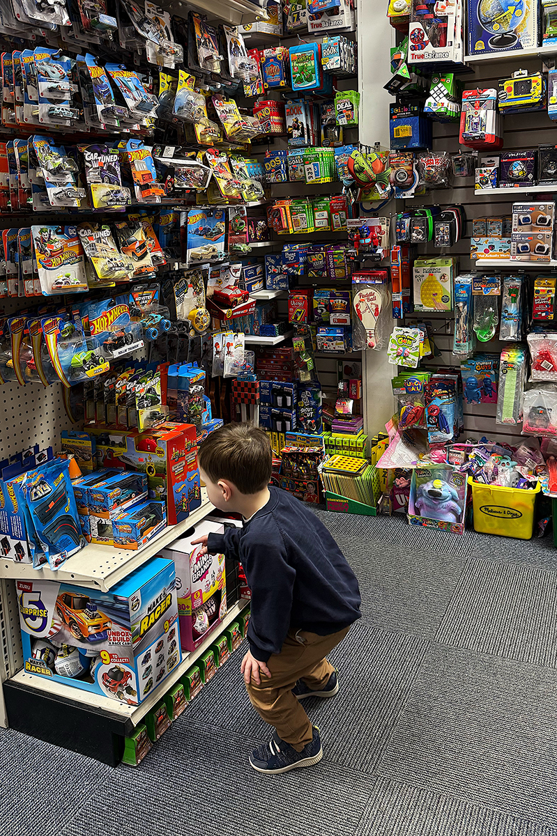 A toddler picking out a toy in a toy store