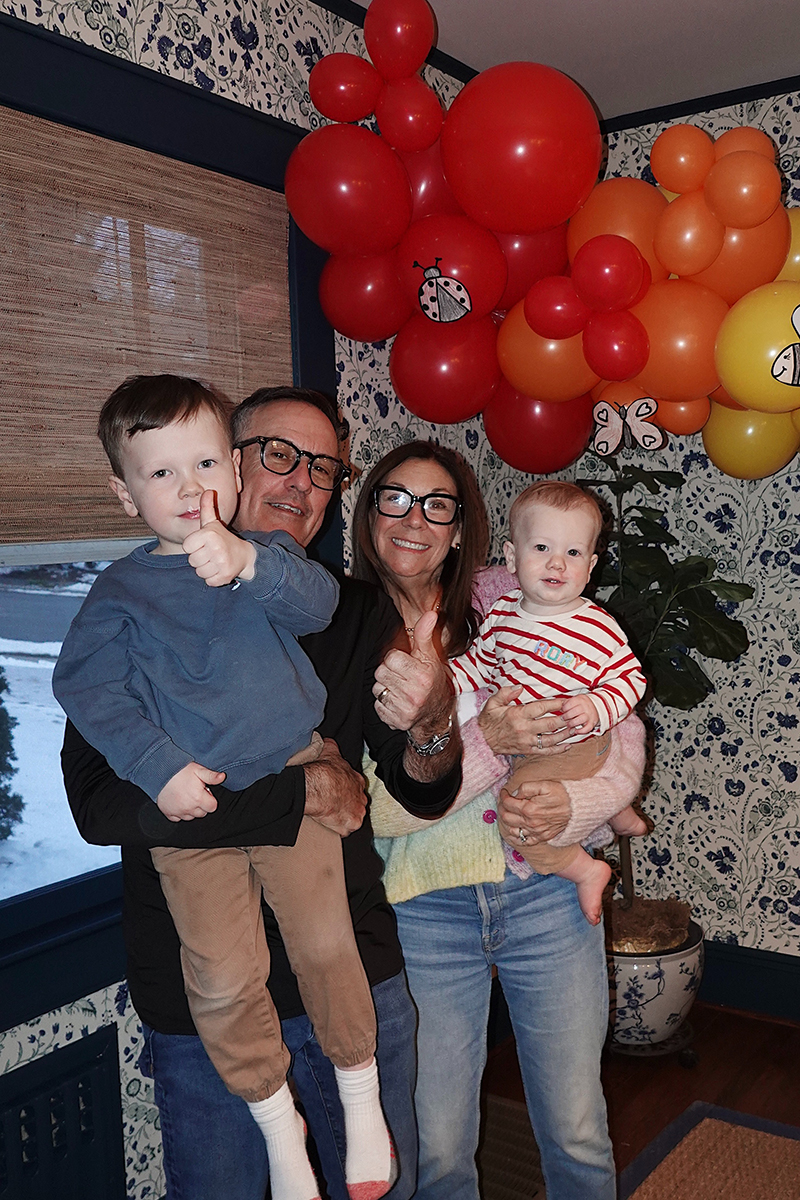 A group family photo in front of a balloon Arch