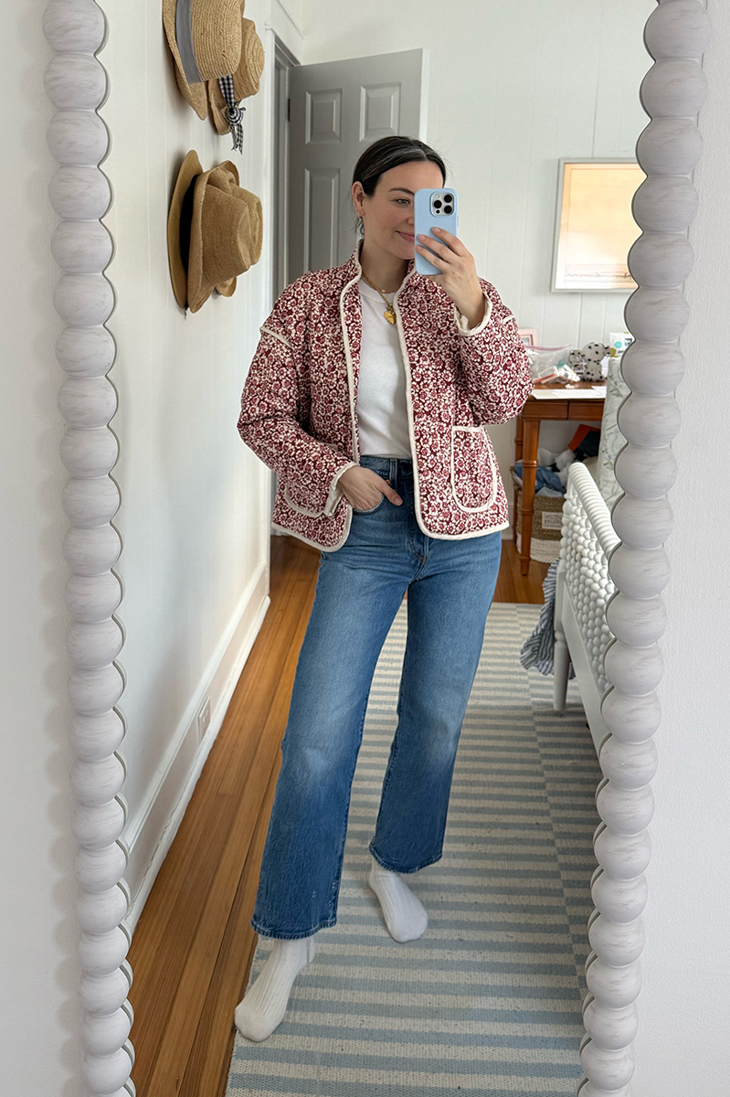 Carly Riordan taking a mirror selfie wearing a floral quilted jacket and jeans!