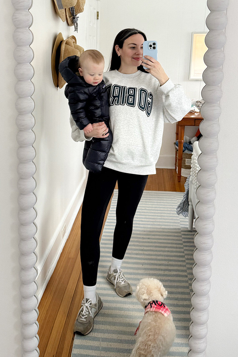 Carly Riordan taking a mirror selfie wearing an eagles sweatshirt and leggings.